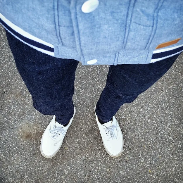 Close up of person wearing baggy jeans with sneakers