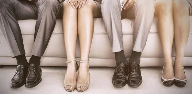 A close-up of a woman's feet showcases three different types of office-appropriate footwear: classic black leather loafers, stylish white sneakers, and elegant nude-colored block heels.
