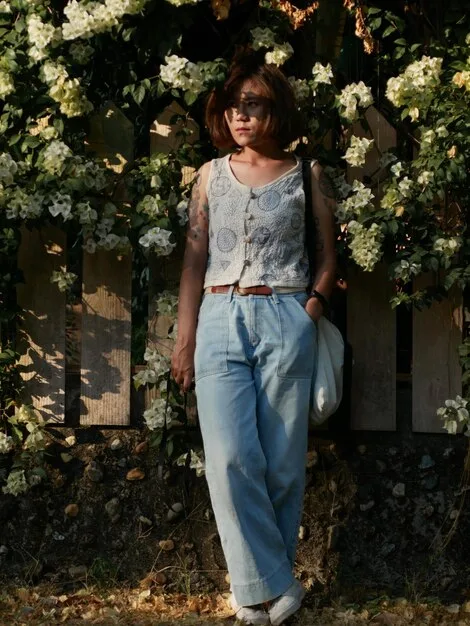 A woman in a casual daytime outfit (jeans and a t-shirt) accessorized with delicate layered necklaces and a convertible crossbody bag. Inset image shows the same woman in an evening dress, holding the same bag as a clutch and wearing the necklaces layered with a statement pendant.
