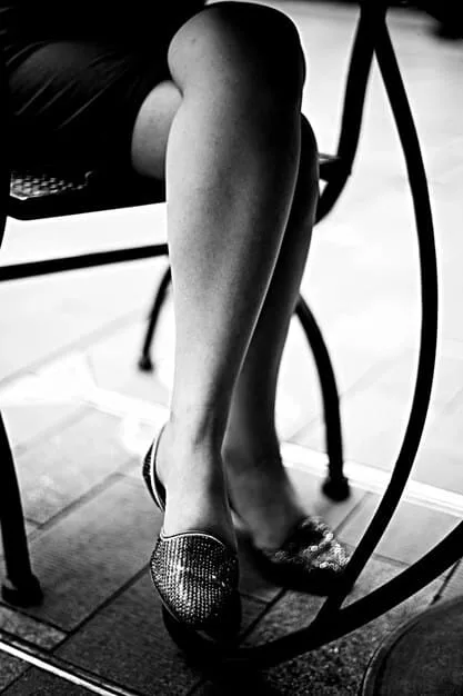 A close-up of Blake Lively's feet, showcasing a pair of eye-catching statement heels with intricate details. The focus is on the shoes and their unique design.