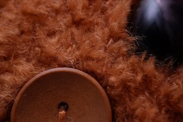 A close-up shot of a luxurious cashmere coat with intricate detailing, possibly displayed in a high-end boutique or department store. Focus on the texture and quality of the fabric.