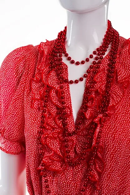 A collection of affordable red carpet-worthy dresses in various styles and colors, displayed on mannequins in a brightly lit boutique. There are flowing gowns, sequined cocktail dresses, and structured sheath dresses, all with price tags clearly visible and under $150.