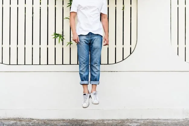 A close-up of light-wash, straight-leg denim jeans paired with classic white low-top sneakers, showing minimalist style.