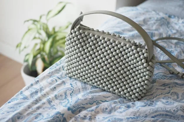 A curated selection of handbags and clutches, including a canvas tote bag, a faux leather crossbody bag, and a beaded clutch. The items are positioned on a white shelf against a light gray wall.