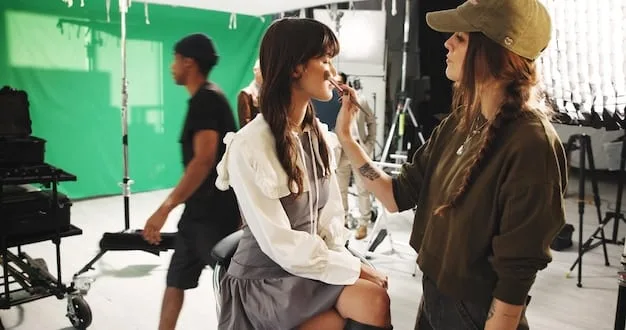 A backstage scene at a major fashion event, with models in intricate outfits being prepped by stylists and makeup artists, capturing the organized chaos and creative energy behind the scenes.