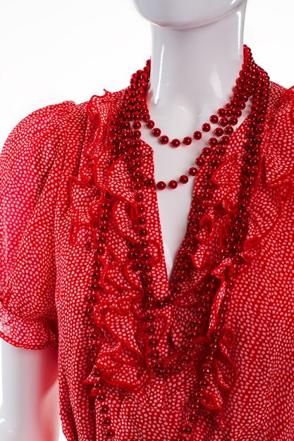 A collection of affordable red carpet-worthy dresses in various styles and colors, displayed on mannequins in a brightly lit boutique. There are flowing gowns, sequined cocktail dresses, and structured sheath dresses, all with price tags clearly visible and under $150.