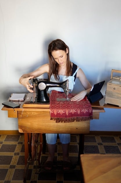 A person sitting at a sewing machine, altering a dress. Various fabrics, patterns, and sewing tools are visible around them.