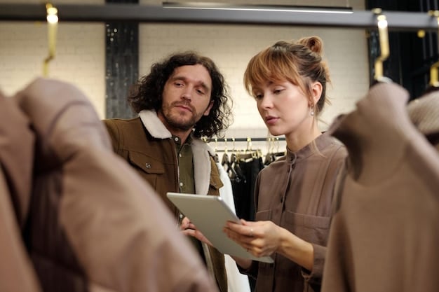 Buyers attentively browsing through clothing racks in a well-designed booth at a fashion trade show, engaging with sales representatives and examining product details.