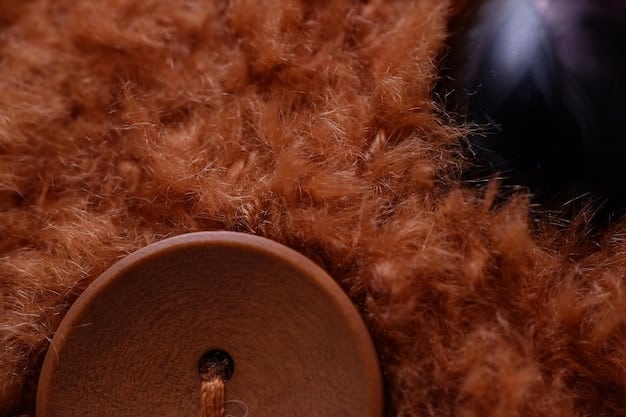 A close-up shot of a luxurious cashmere coat with intricate detailing, possibly displayed in a high-end boutique or department store. Focus on the texture and quality of the fabric.