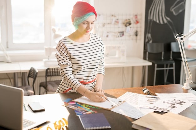 A fashion designer working in a bright, modern studio in New York City, with sketches and fabric samples surrounding them.