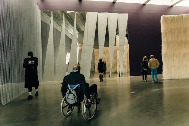 A close-up shot of a wheelchair-accessible ramp seamlessly integrated into a US fashion event entrance, adorned with stylish decorations and lighting.