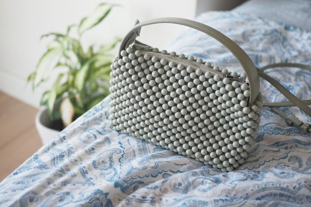 A curated selection of handbags and clutches, including a canvas tote bag, a faux leather crossbody bag, and a beaded clutch. The items are positioned on a white shelf against a light gray wall.