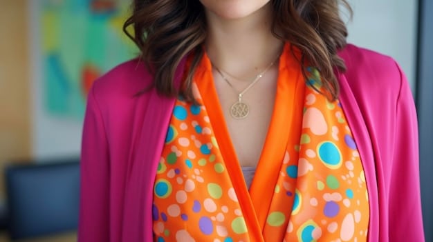 A close-up shot of a stylish work-from-home outfit featuring a simple top, delicate necklace, and a brightly colored scarf.