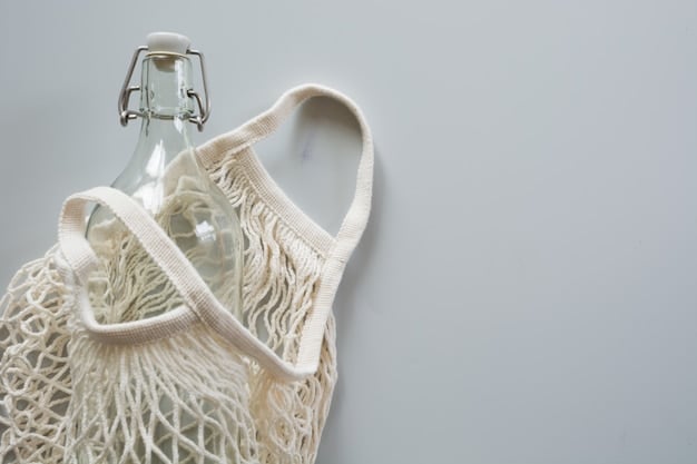 A brightly lit rack displaying clothing from an eco-friendly brand. The clothes are simple, stylish, and made from natural fabrics. The brand's logo is subtly visible in the background.