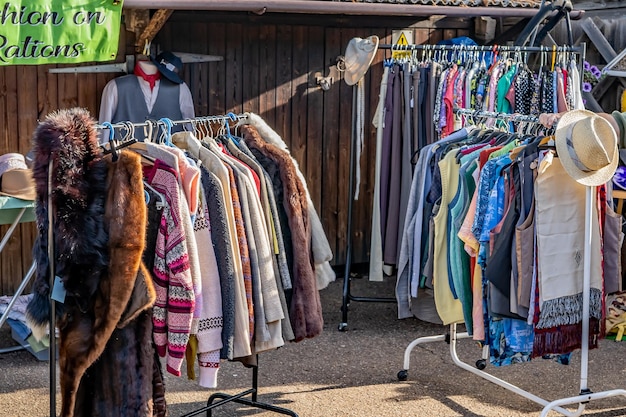 A well-organized thrift store rack showcasing a variety of clothing items, including vintage dresses, tailored blazers, and unique accessories. The image should highlight the potential for finding high-quality, stylish pieces in a thrift store setting.