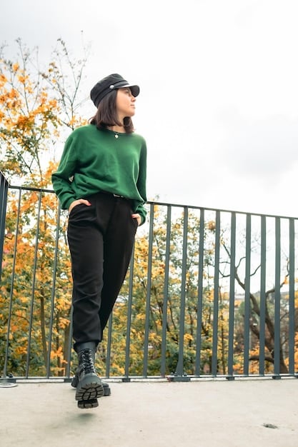 A person wearing a fall-themed athleisure outfit, featuring a long-sleeve top in earthy tones, paired with dark leggings and stylish running shoes. The background showcases autumn foliage, creating a cozy and stylish scene.