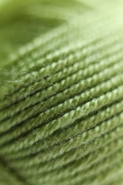 A close-up of a sustainable fabric sample, possibly made from recycled ocean plastic or organic cotton. The texture of the fabric is visible, highlighting its unique weave and eco-friendly properties.