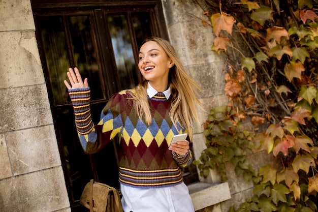 A fashion blogger showcasing a fall outfit consisting of a plaid blazer, a cable-knit sweater, and dark wash jeans. She is standing in front of a brick wall, and the overall aesthetic is cozy and autumnal.