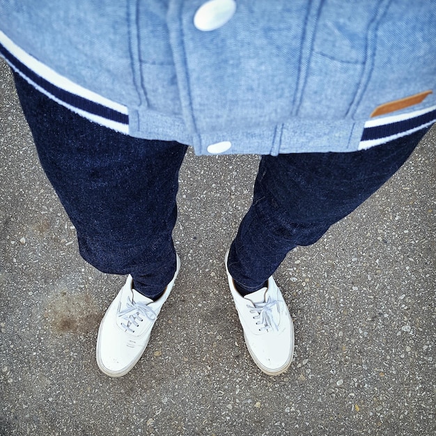 Close up of person wearing baggy jeans with sneakers