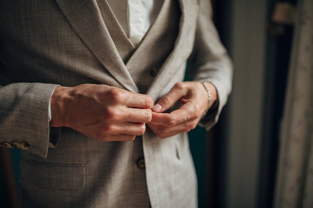 A close-up shot of a woman's hands adjusting the lapel of a perfectly tailored blazer in a neutral color, showcasing the impeccable details and high-quality fabric. The focus is on the precision stitching and the elegant texture of the material.