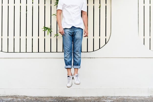 A close-up of light-wash, straight-leg denim jeans paired with classic white low-top sneakers, showing minimalist style.