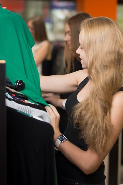 A fashion professional examining sustainable textile swatches at an exhibition booth, surrounded by informational displays about eco-friendly materials and circular fashion. The ambiance is modern and bright.