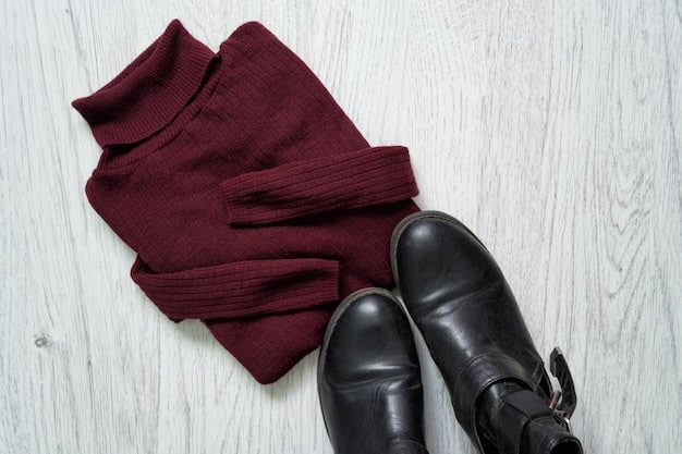 A flat lay of a perfectly styled outfit featuring a white t-shirt, dark wash jeans, black knit sweater, and a colorful scarf, demonstrating effective accessorizing and layering for versatile wear.