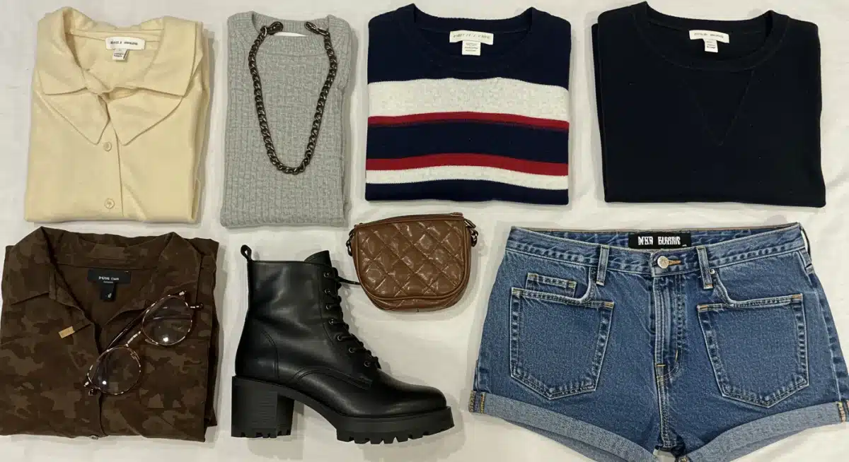 Collection of stylish thrifted designer clothing and accessories laid out on a clean surface.